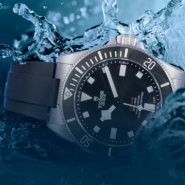 Eine schwarze Tudor-Taucheruhr mit Edelstahlgehäuse ist teilweise in Wasser getaucht und zeigt so ihre Wasserdichtigkeit. Das schwarze Zifferblatt mit weißen Stundenmarkierungen und Zeigern wird durch das Logo der Marke ergänzt. Erhältlich bei Juwelier Morawitz, Düsseldorf.