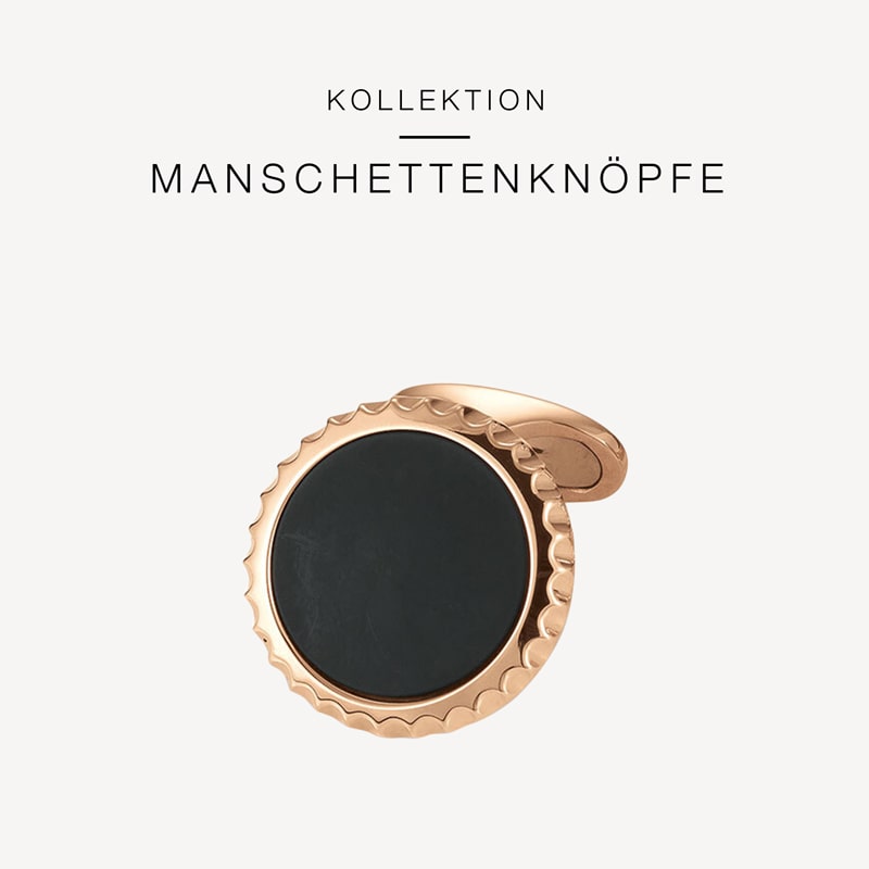 Abgebildet ist ein einzelner Manschettenknopf mit Roségold-Finish und runder schwarzer Mitte. Der Hintergrund ist weiß, über dem Manschettenknopf steht der deutsche Text „KOLLEKTION MANSCHETTENKNÖPFE“. Erhältlich bei Juwelier Morawitz in Düsseldorf.