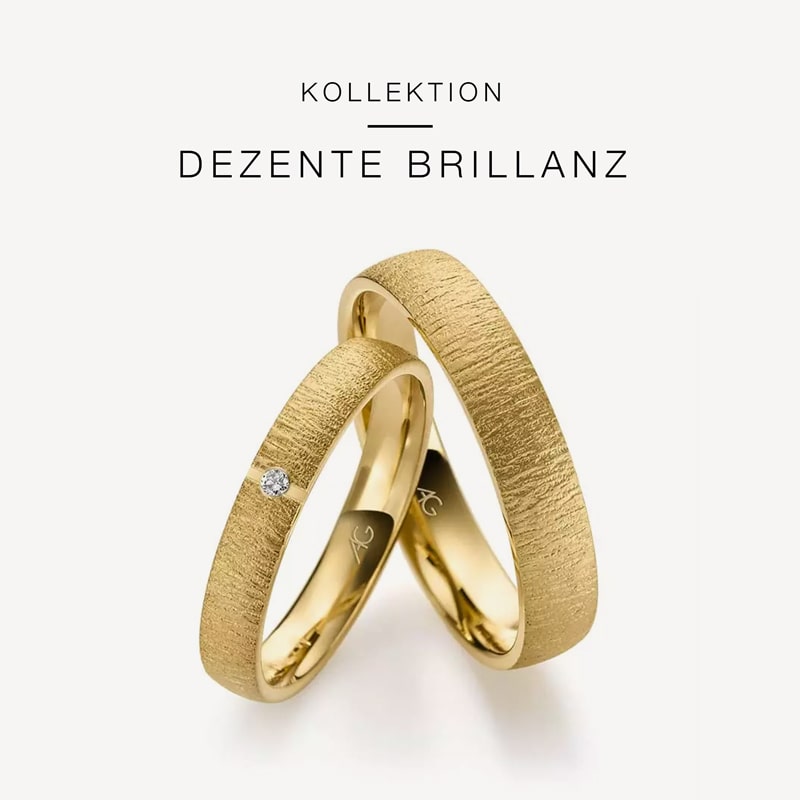 Juwelier-Morawitz-Gerstner-Kollektion-Dezente-Brillanz Eine Anzeige präsentiert zwei elegante Goldringe aus der Kollektion „Dezente Brillanz“ von Juwelier Morawitz in Düsseldorf. Die Ringe haben eine strukturierte Oberfläche, wobei der dünnere Ring mit einem kleinen Diamanten besetzt ist. Der Hintergrund ist weiß und über den Ringen ist der Name der Kollektion zu sehen.