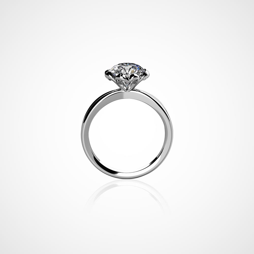 Juwelier-Morawitz-Schmucklexikon-solitaer Ein schlichter, minimalistischer Verlobungsring von Juwelier Morawitz in Düsseldorf zeigt einen Diamanten im Rundschliff in einer klassischen Krappenfassung vor einem schlichten weißen Hintergrund. Die schlichte Ringschiene betont das Funkeln und die Klarheit des Diamanten.