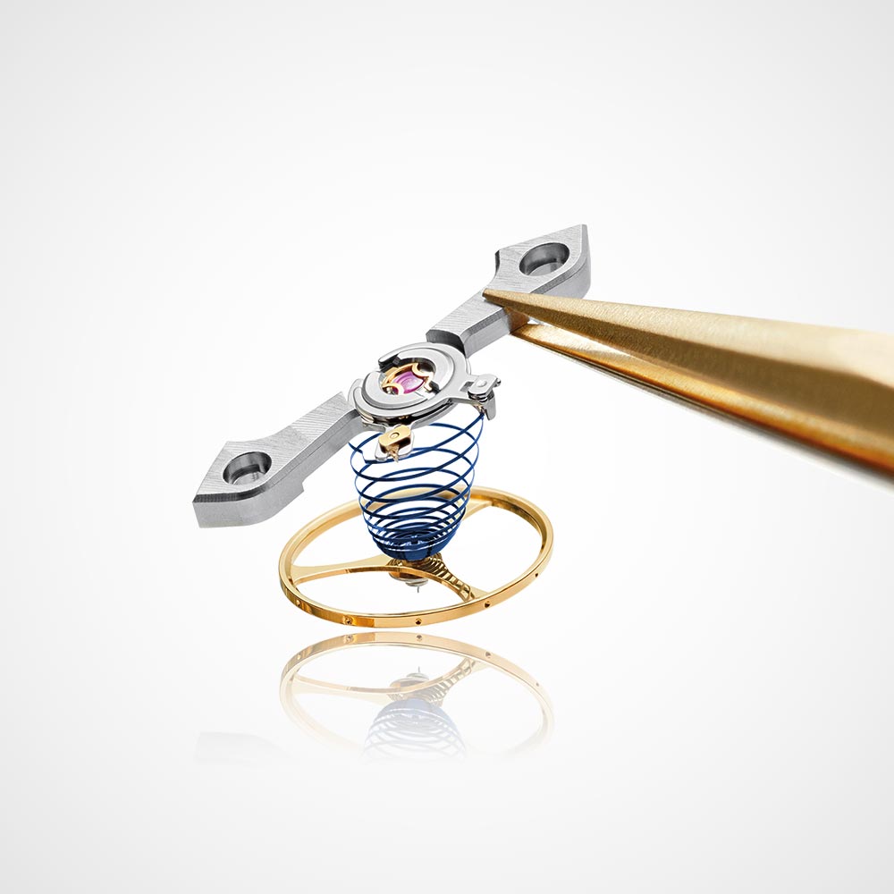 Juwelier-Morawitz-Uhrenlexikon-unruh Eine Nahaufnahme von Präzisionsuhrmacherwerkzeugen, die ein winziges, kompliziertes Unruhrad und einen Federmechanismus halten. Die Komponenten sind metallisch mit einer goldenen und blauen Färbung. Der Hintergrund ist eine saubere, weiße Oberfläche, die die detaillierte Handwerkskunst von Juwelier Morawitz in Düsseldorf hervorhebt.