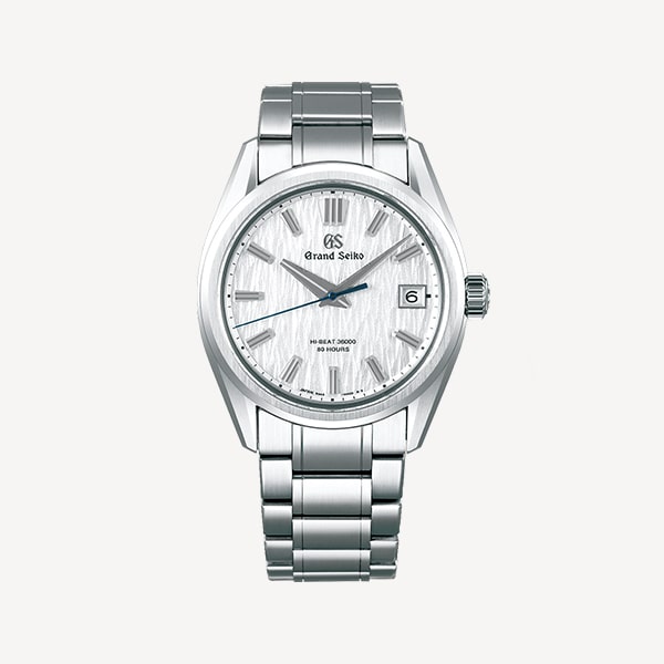 Juwelier-Morawitz-Box-Grand-Seiko-Uhr-Beige Eine silberne Luxusarmbanduhr von Grand Seiko, erhältlich bei Juwelier Morawitz in Düsseldorf, verfügt über ein strukturiertes weißes Zifferblatt mit silbernen Stundenmarkierungen und Zeigern. Sie verfügt über ein Datumsfenster auf der 3-Uhr-Position und wird durch ein Edelstahlarmband und eine Edelstahllünette ergänzt.