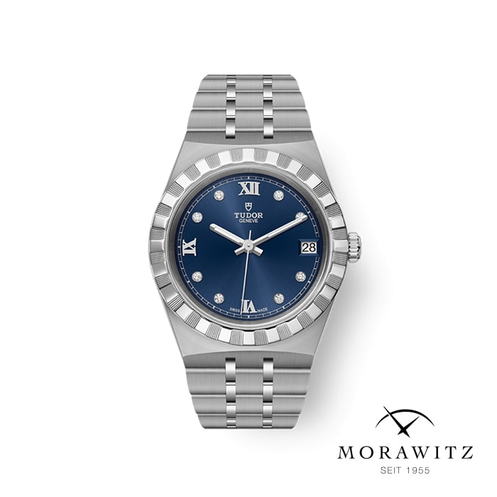 Eine elegante silberne Tudor-Armbanduhr mit poliertem Metallarmband und blauem Zifferblatt. Das Zifferblatt verfügt über silberne Stundenmarkierungen, römische Ziffern bei 12 und 6 sowie ein Datumsfenster bei 3 Uhr. Das Markenlogo und „Tudor“ sind unterhalb der 12-Uhr-Position zu sehen. Morawitz-Logo darunter.