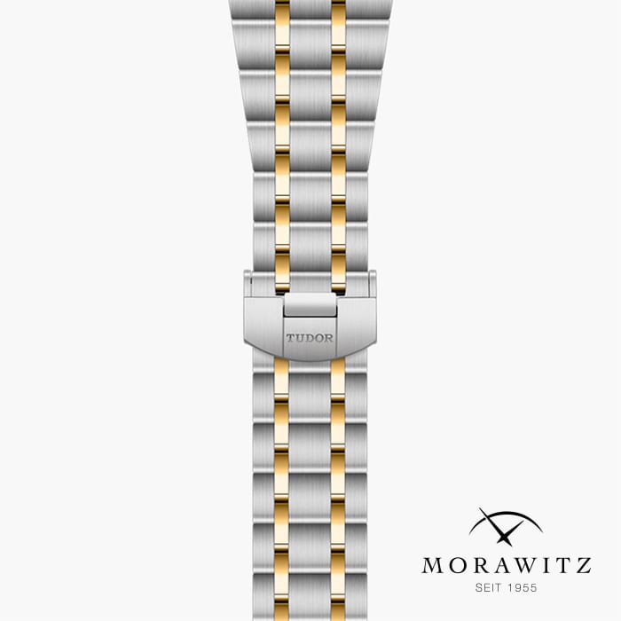 Eine Nahaufnahme eines Armbanduhrenarmbands der Marke Tudor. Das Armband besteht aus abwechselnd silbernen und goldenen Metallgliedern. In der unteren rechten Ecke des Bildes ist das Markenlogo „Morawitz“ mit dem Text „SEIT 1955“ zu sehen.