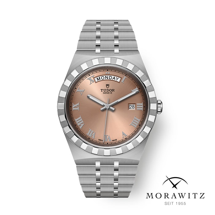 Eine silberne Tudor-Armbanduhr mit lachsfarbenem Zifferblatt und römischen Stundenmarkierungen. Der Tag wird auf der 12-Uhr-Position und das Datum auf der 3-Uhr-Position angezeigt. Die Uhr verfügt über ein Metallgliederarmband und unten rechts steht der Text „MORAWITZ SEIT 1955“.