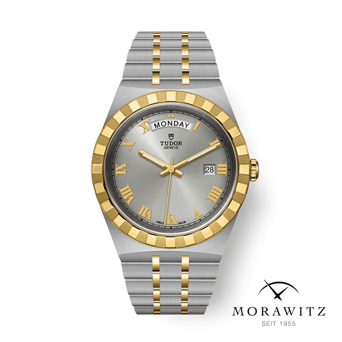 Eine Tudor-Armbanduhr in silber- und goldfarbenem Design mit Tages- und Datumsanzeige. Die Uhr hat ein silbernes Zifferblatt mit goldenen römischen Ziffern und Zeigern. Das Armband ist silberfarben mit goldenen Akzenten. In der unteren rechten Ecke ist das Logo „Morawitz Seit 1955“ zu sehen.