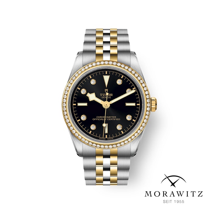 Eine Luxusarmbanduhr mit schwarzem Zifferblatt, goldenen Stundenmarkierungen und einem zweifarbigen Armband aus Gold und Silber. Die Lünette ist mit kleinen Diamanten verziert und auf dem Zifferblatt ist der Markenname „Tudor“ zu sehen. In der unteren rechten Ecke ist „MORAWITZ SEIT 1955“ abgebildet.
