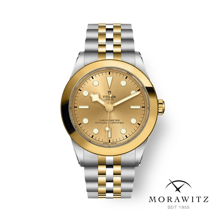 Eine luxuriöse Armbanduhr mit zweifarbigem Design in Gold und Silber. Das Zifferblatt ist goldfarben mit goldenen Stundenmarkierungen und Zeigern. Die Lünette ist goldfarben und das Armband besteht aus einer Mischung aus goldenen und silbernen Gliedern. Der Markenname und das Logo von Tudor sind auf dem Zifferblatt sichtbar. Das Morawitz-Logo befindet sich in der unteren rechten Ecke.