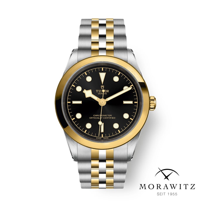 Eine Tudor-Armbanduhr mit schwarzem Zifferblatt, goldenen Markierungen und Zeigern und einer Mischung aus Silber- und Goldtönen am Armband. Das Logo „Morawitz“ und der Text „SEIT 1955“ sind in der unteren rechten Ecke zu sehen.
