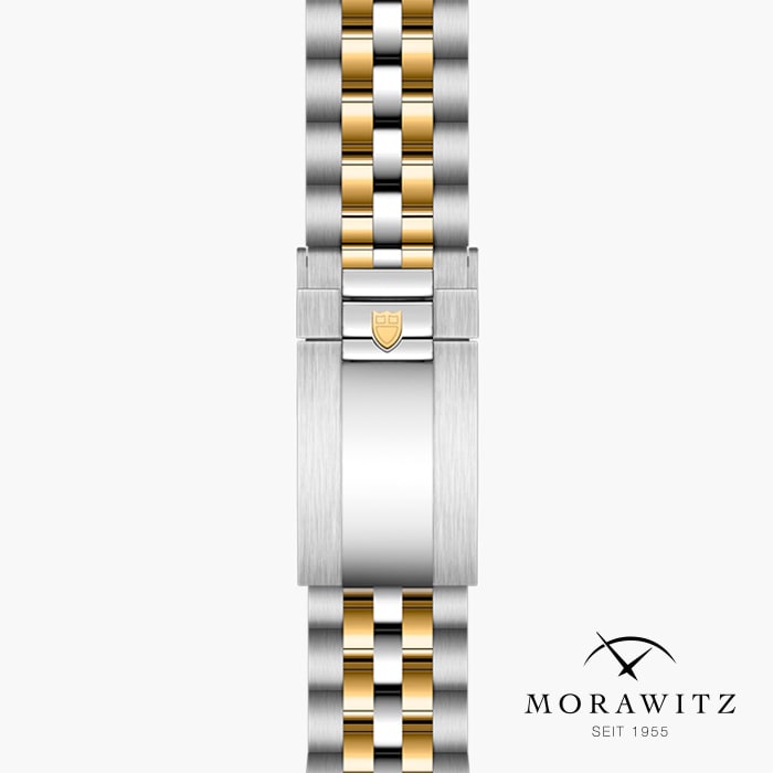 Eine Nahaufnahme eines Luxusarmbands mit einer Mischung aus silbernen und goldenen Gliedern und einem Verschluss mit einem geprägten Schildlogo. Der Markenname „Morawitz“ sowie der Text „Seit 1955“ sind in der unteren rechten Ecke zu sehen.