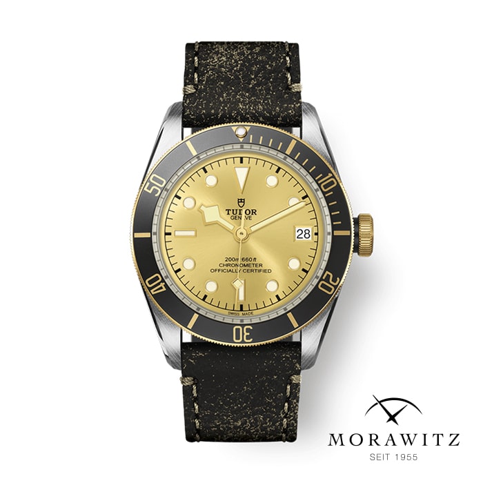 Eine Tudor-Taucheruhr mit beigem Zifferblatt, schwarzer Lünette und schwarzem Lederarmband. Das Zifferblatt zeigt das Datum auf der 3-Uhr-Position. Das Bild zeigt außerdem das Morawitz-Logo mit dem Text „MORAWITZ SEIT 1955“ in der unteren rechten Ecke.