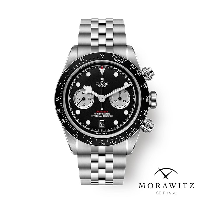 Die TUDOR BLACK BAY CHRONO ist eine Chronographenuhr aus Edelstahl mit schwarzem Zifferblatt, silbernen Hilfszifferblättern und Datumsfenster an einem Metallarmband. Abgebildet über dem Morawitz-Logo mit dem Text "SEIT 1955".