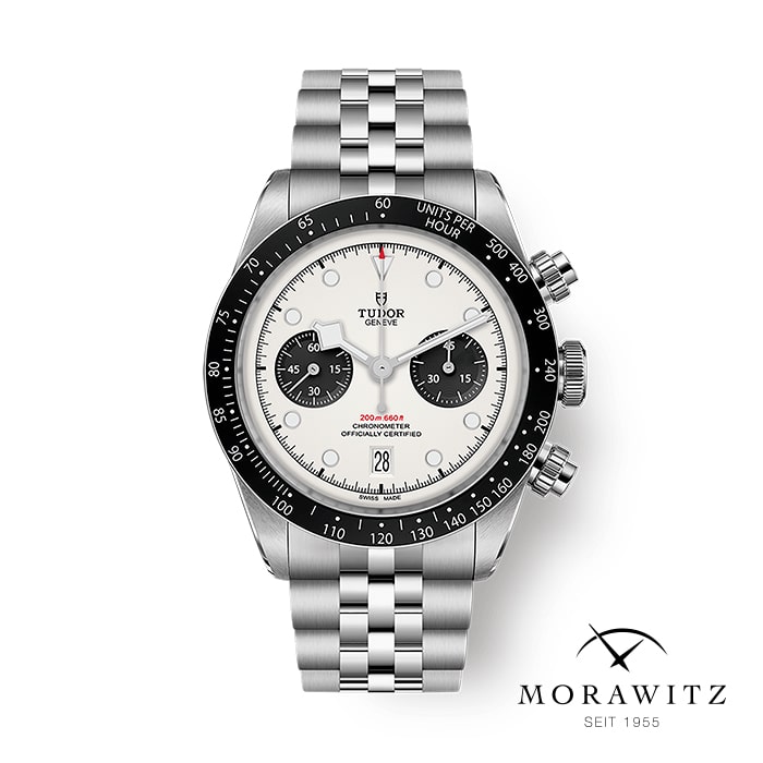 Eine TUDOR BLACK BAY CHRONO Uhr mit silbernem Gehäuse, weißem Zifferblatt mit schwarzen Hilfszifferblättern und Edelstahlarmband. Das Morawitz-Logo und der Text "SEIT 1955" erscheinen in der unteren rechten Ecke.