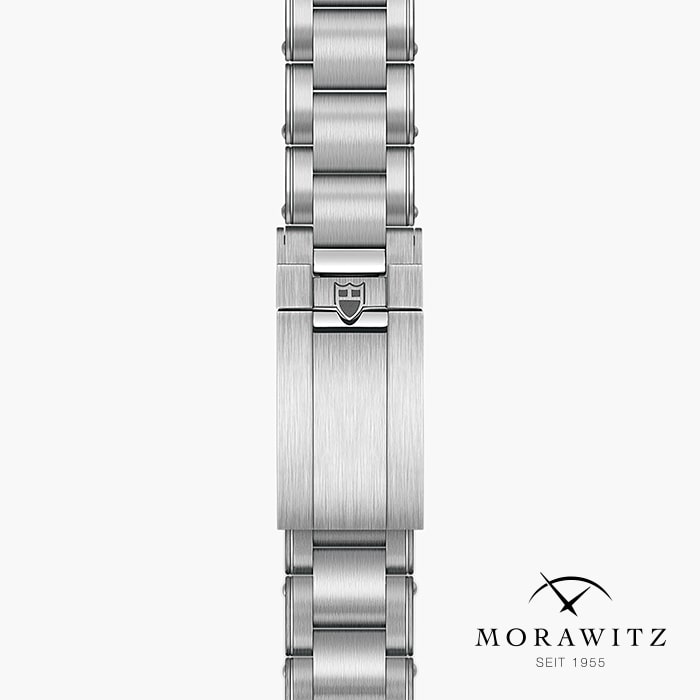 Eine Nahaufnahme einer silbernen Metallschließe mit einem Schildlogo der TUDOR BLACK BAY PRO Uhr ist vertikal auf weißem Hintergrund zu sehen. Das Morawitz-Logo und "SEIT 1955" erscheinen unten rechts.