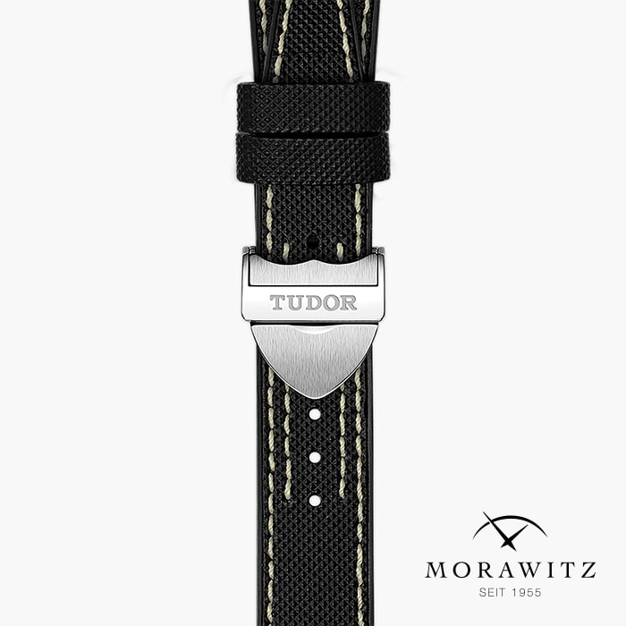 Nahaufnahme des schwarz strukturierten Armbands der TUDOR BLACK BAY PRO mit weißen Nähten und einer silbernen Schließe mit der Gravur "Tudor". Das Morawitz-Logo mit gekreuzten Linien und "Seit 1955" erscheint in der unteren rechten Ecke.